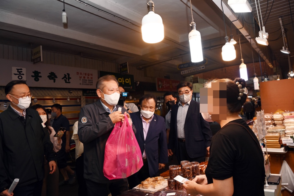 이상민 행정안전부 장관이 1일 오후 안전대전환과 관련해 폭염대비 여름철 안전점검하기 위해 서울 종로구 광장시장을 방문해 관계자들과 함께 시장을 둘러보고 선물을 구입하고 있다.
