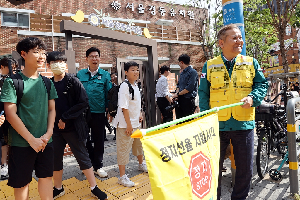 Minister Lee Sang-min gives traffic guidance at a pedestrian crossing during a traffic safety campaign in front of Gyeongdong Elementary School in Seoul on the afternoon of the 18th.