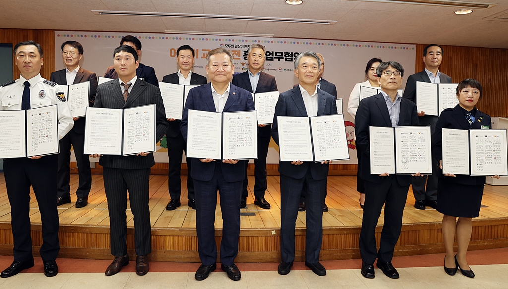 Minister Lee Sang-min (front row, third from left) poses for a photo with representatives of 13 institutions including central ministries, government agencies, private companies, and civil societies at Gyeongdong Elementary School in Seoul after signing an MOU on Traffic Safety for Children on the afternoon of the 18th.